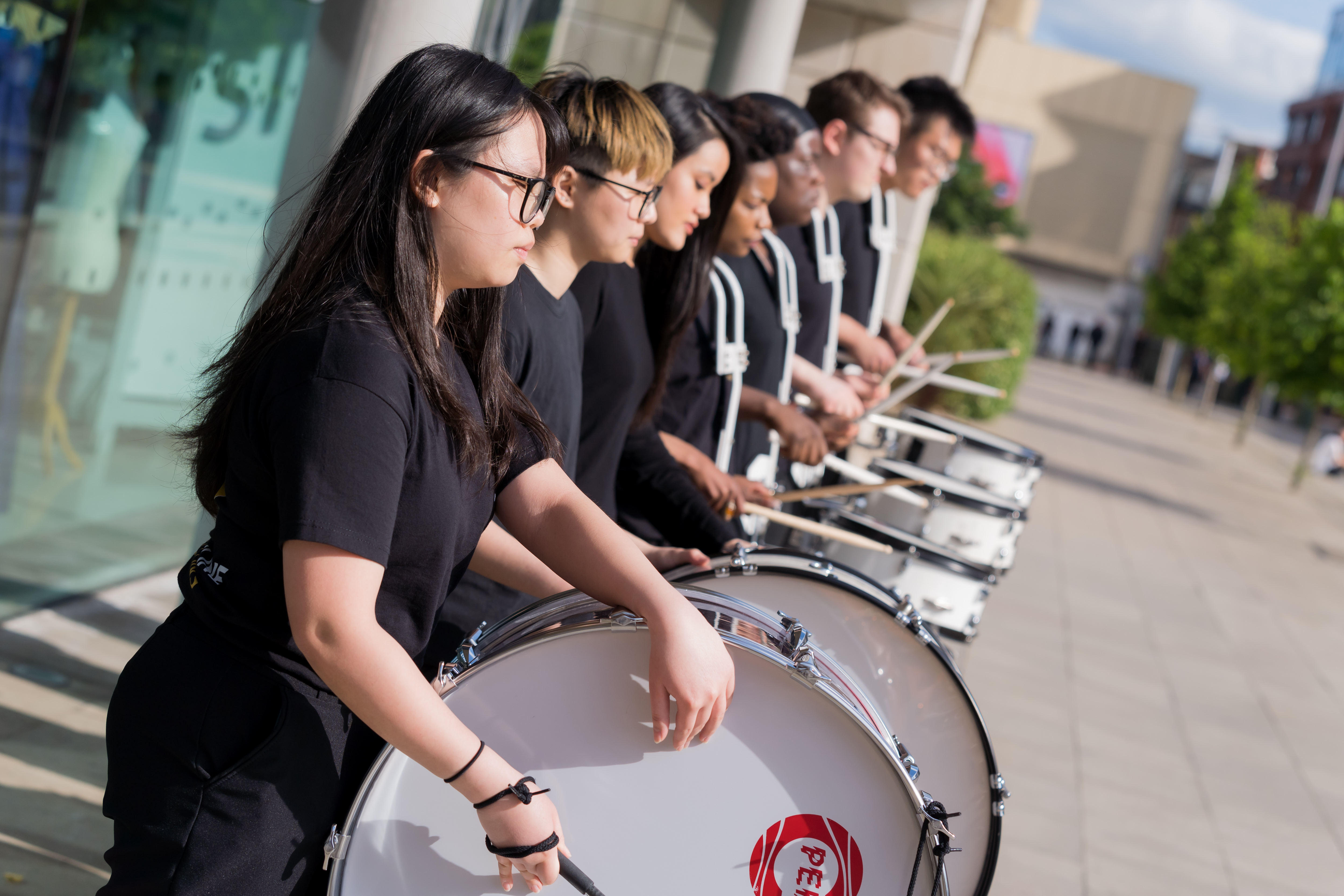 A row of students playing the drums.