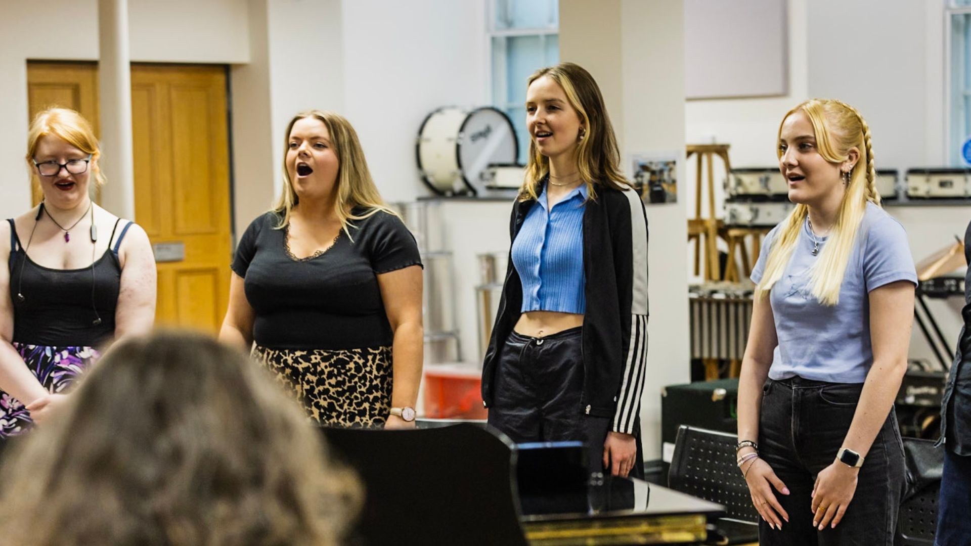 Students singing in front of a pianist.