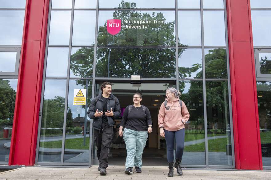 Three students in front of NTU Mansfield building