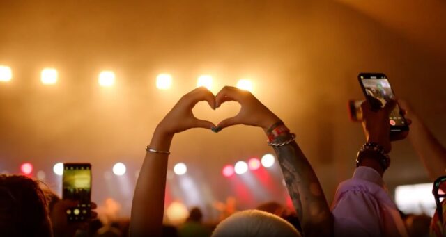 Person making heart symbol with hands at event